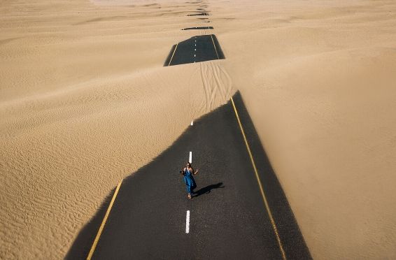 woman walking down sandy road
